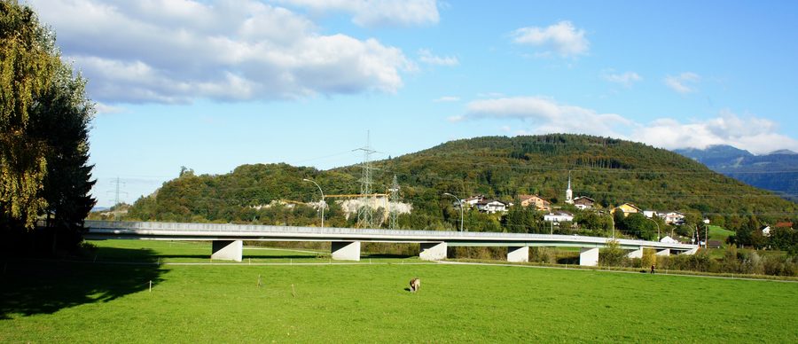 Blick aus Südwesten auf die Brücke über den Rhein bei Montlingen, im Hintergrund der Kummenberg und davor Koblach